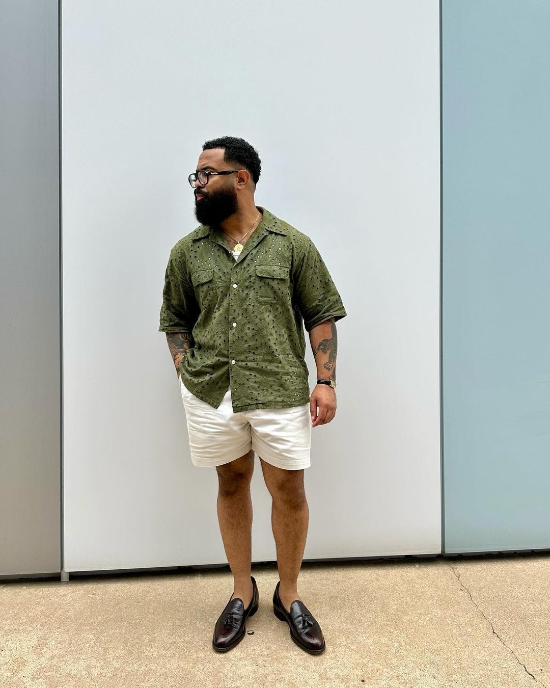 man wearing a short-sleeve green shirt with khaki shorts and black loafers