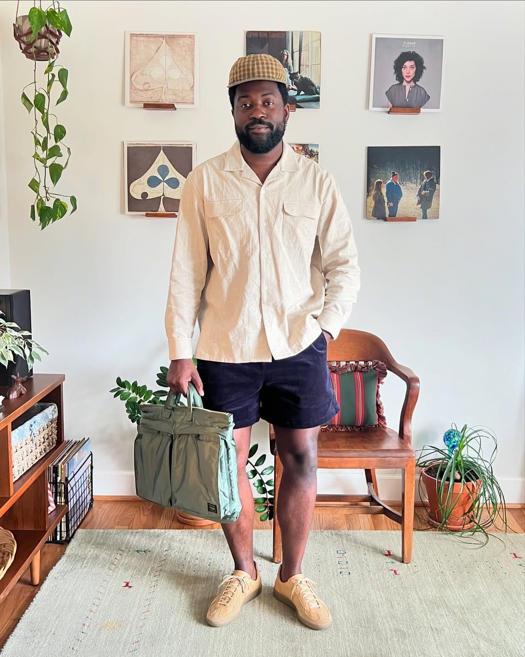 stylish man wearing a long-sleeve camp shirt with dark shorts