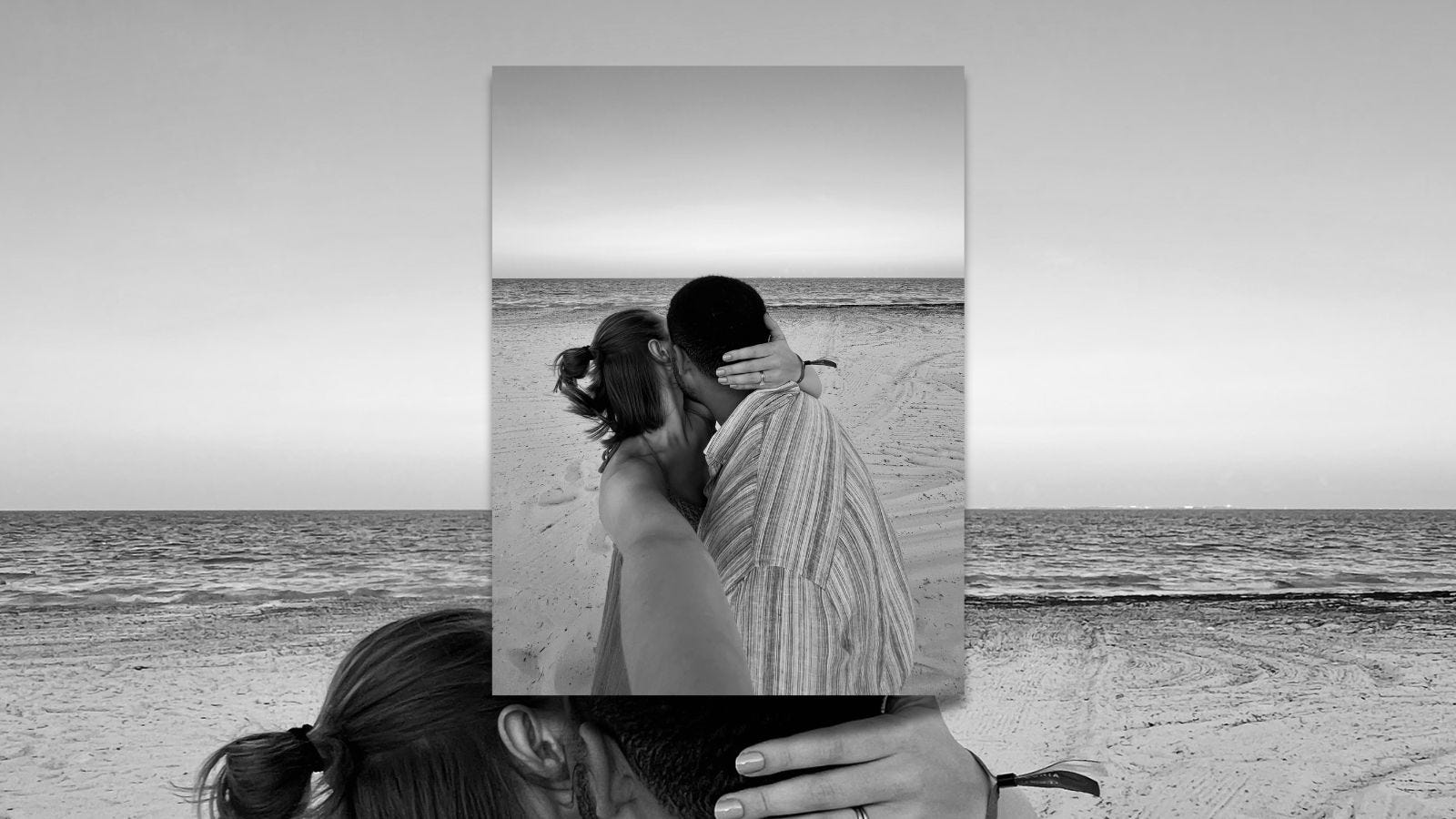 black and white photo of a couple kissing on the beach