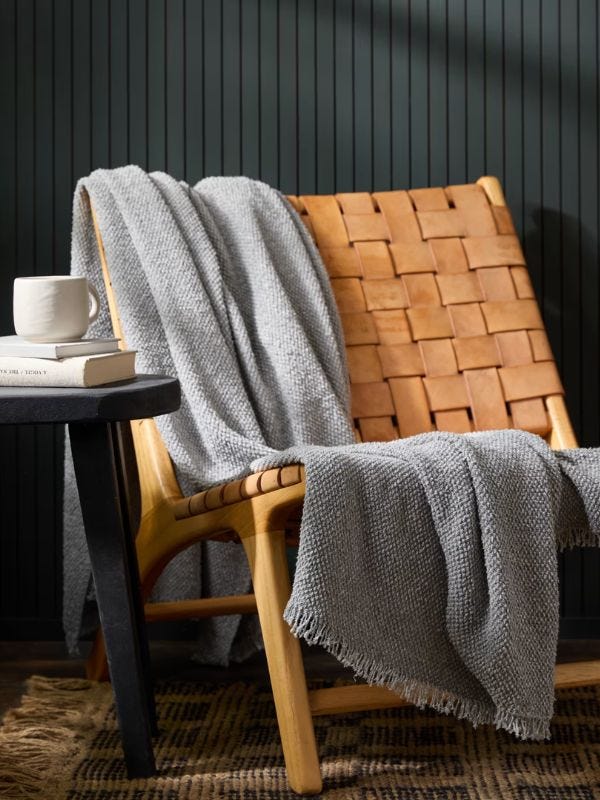 accent chair with a light blue throw blanket draped over it