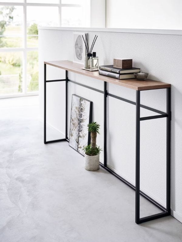 console table with books and a scent diffuser sitting on top